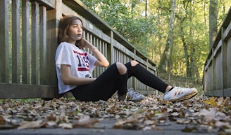 Model walking outdoors wearing a relaxed fit t-shirt and jeans, surrounded by autumn leaves