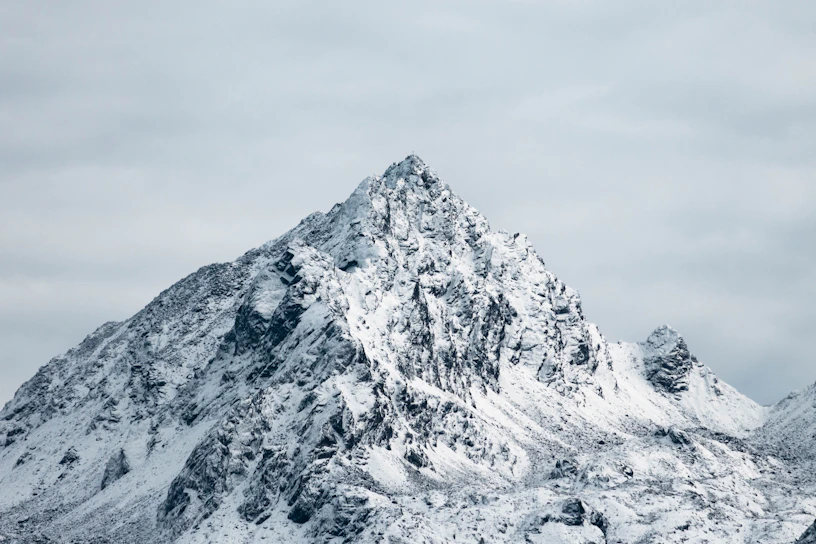 A rugged mountain peak silhouetted against a stormy sky, symbolizing strength and perseverance.