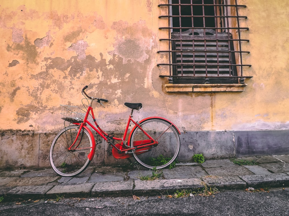 빨간 자전거가 벽에 기대어