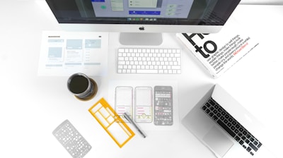 silver MacBook Air on table near iMac