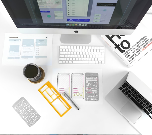 silver MacBook Air on table near iMac