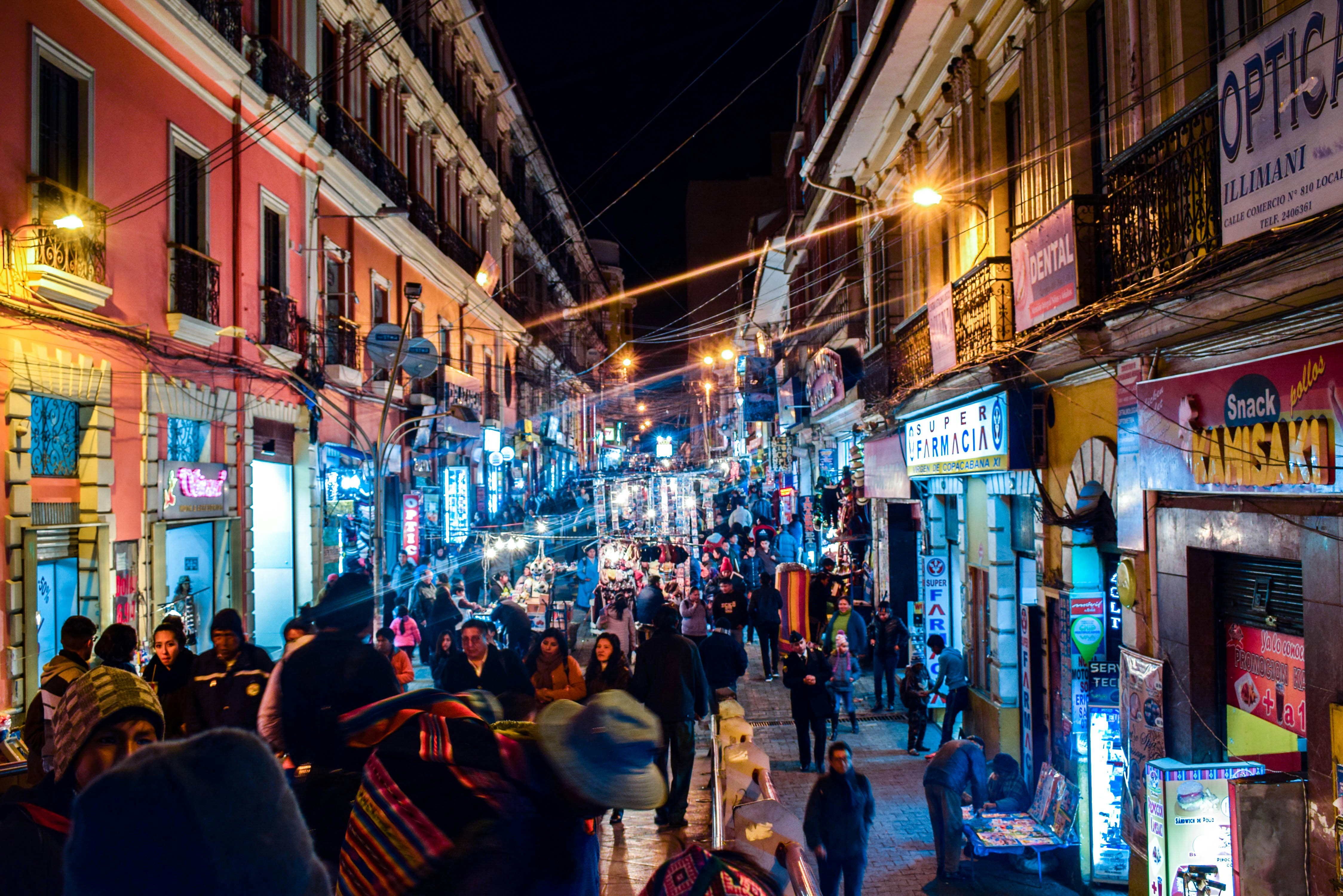 Busy urban street at night with glowing shop signs, pedestrians, and warm streetlights in Bangalore