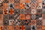 a close up of a tiled wall with orange and black designs
