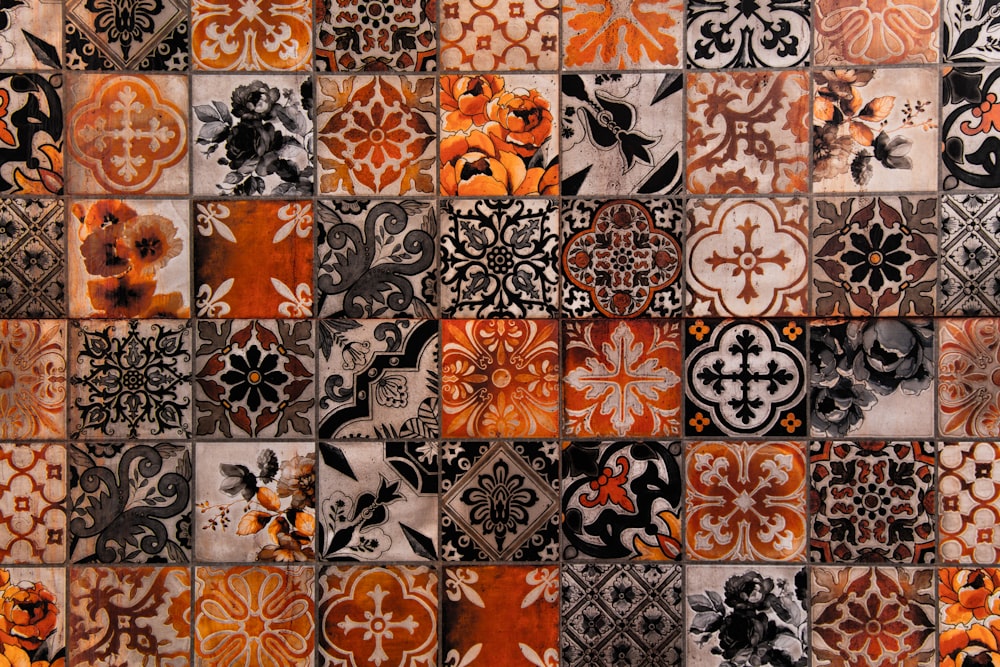 Eine Nahaufnahme einer gekachelten Wand mit orangefarbenen und schwarzen Mustern