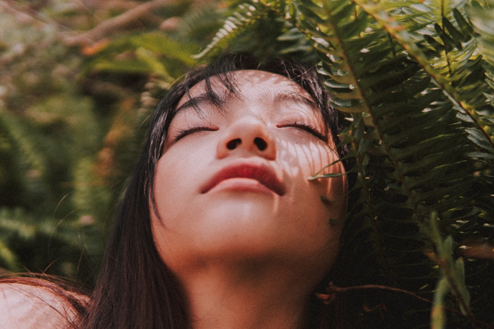 Mulher perto da planta de samambaia