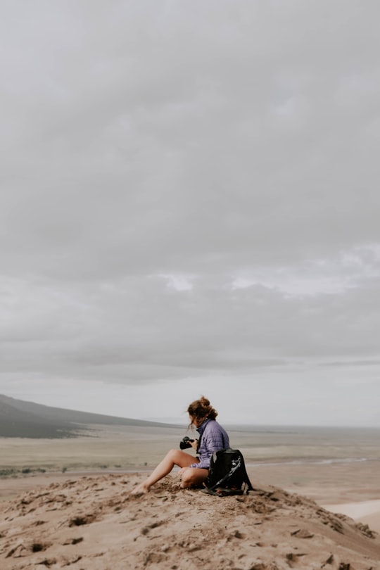 woman sitting on sand in Great Sand Dunes National Park and Preserve United States