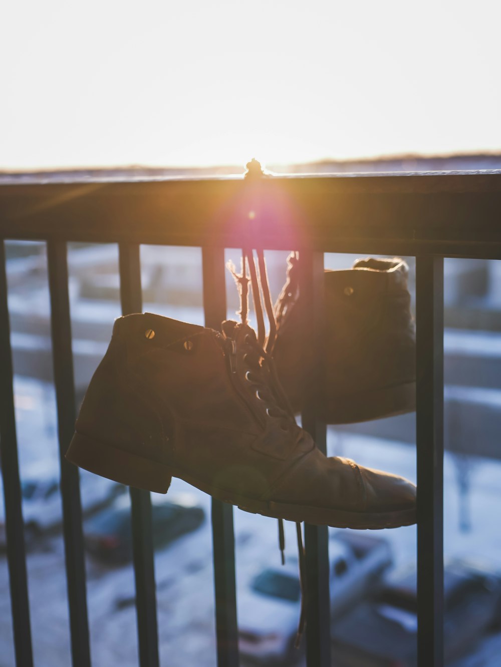 brown leathers shoes hanged on black railings