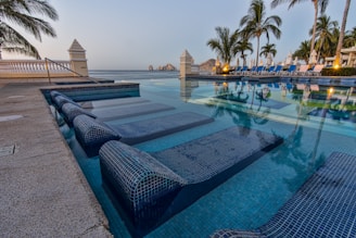 Swimming pool area with loungers overlooking the ocean.
