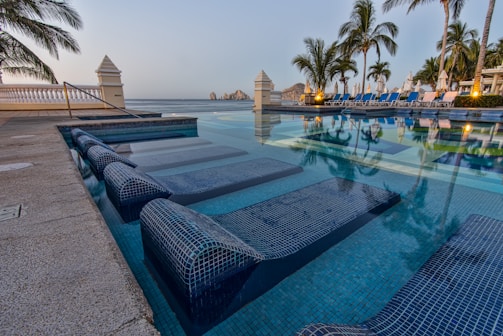 Sunlit view of Casa Luzia's private saltwater pool surrounded by desert plants and lounge chairs.
