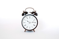 round black and white analog alarm clock