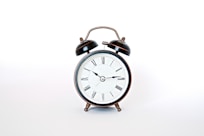 round black and white analog alarm clock