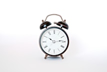 round black and white analog alarm clock