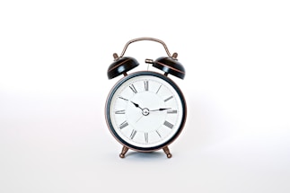 round black and white analog alarm clock