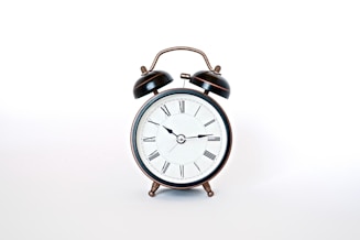 round black and white analog alarm clock