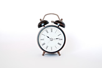 round black and white analog alarm clock