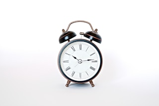 round black and white analog alarm clock