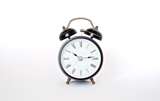 round black and white analog alarm clock