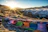 A serene sunrise over the snow-capped peaks of Adi Kailash, with pilgrims walking along a mountain trail.