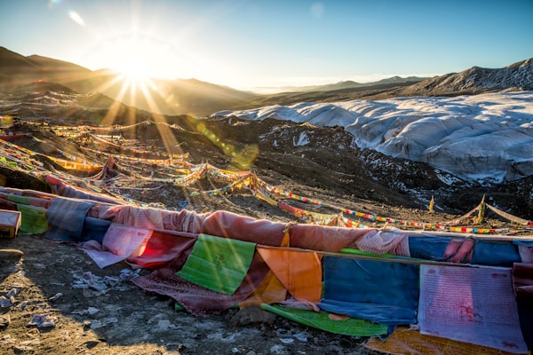 Tibetan prayer flags against a mountainous sunrise