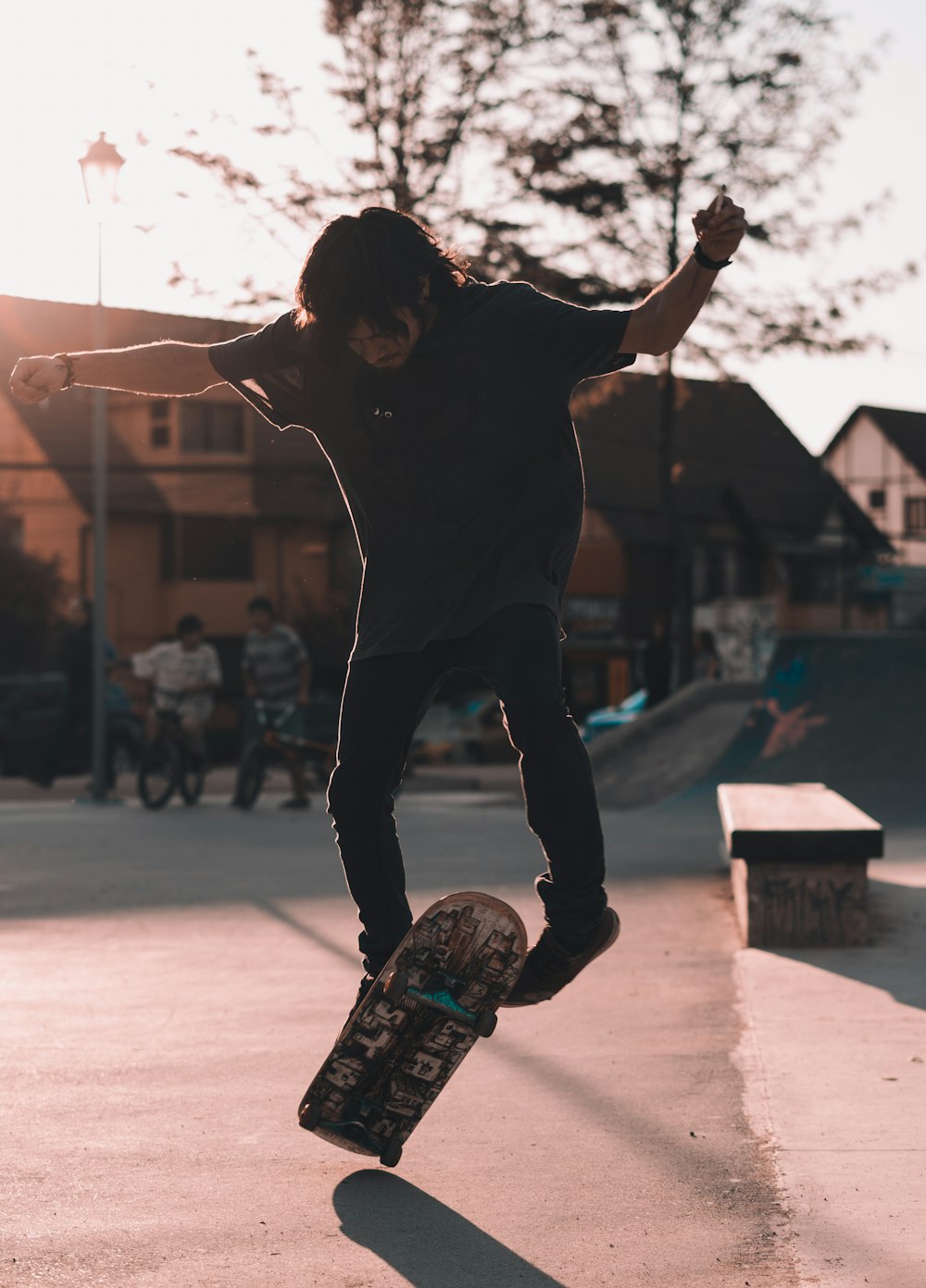 uomo in nero esegue trick sullo skateboard
