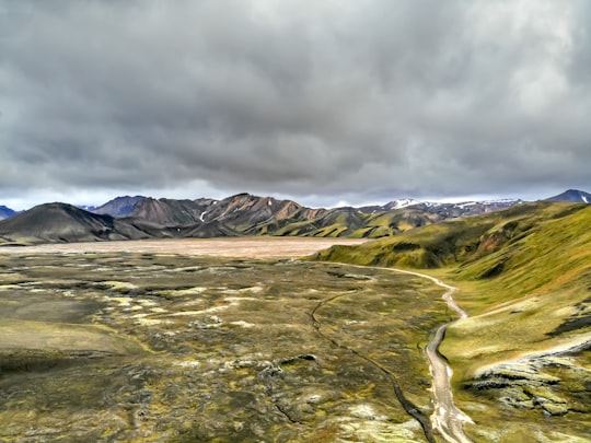 green open field viewing mountain during daytime in Fjallabaksleið Nyrðri Iceland
