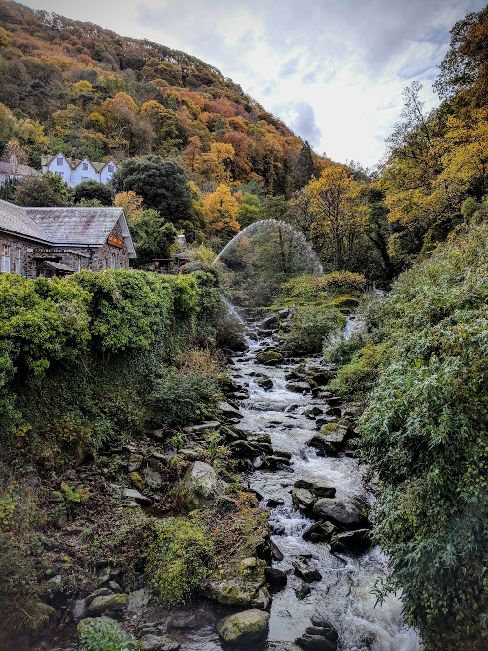 Casa cerca del río debajo de la colina durante el día