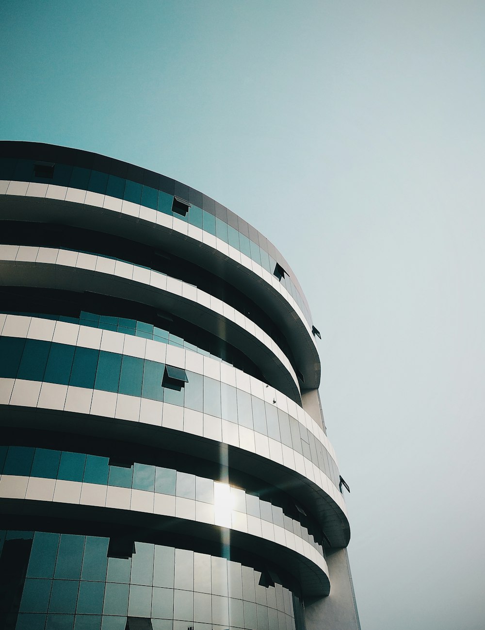 low angle photography of glass building under clear blue sky