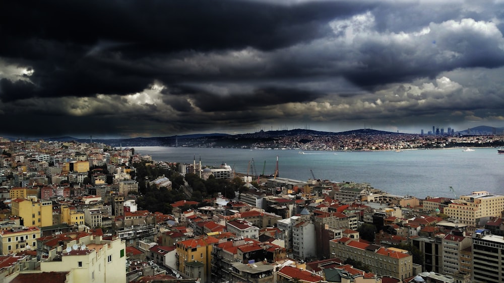 stormy clouds above city buildings near body of water