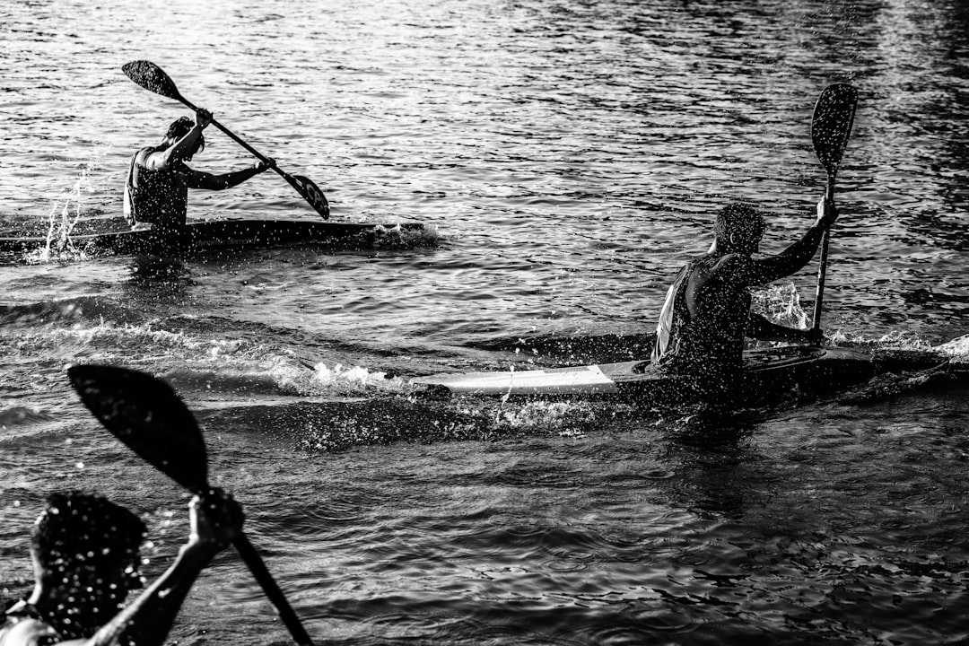 three men paddling kayak on water