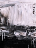 An abstract painting featuring bold brushstrokes in a monochrome palette. The textured canvas displays a mix of light and dark tones, creating a sense of depth and movement. Irregular shapes and lines form a dynamic composition, with a contrast between light grey and dark black areas.