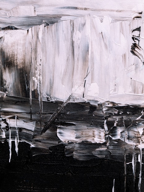 An abstract painting featuring bold brushstrokes in a monochrome palette. The textured canvas displays a mix of light and dark tones, creating a sense of depth and movement. Irregular shapes and lines form a dynamic composition, with a contrast between light grey and dark black areas.