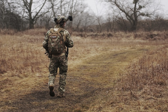 man walking on brown grass field