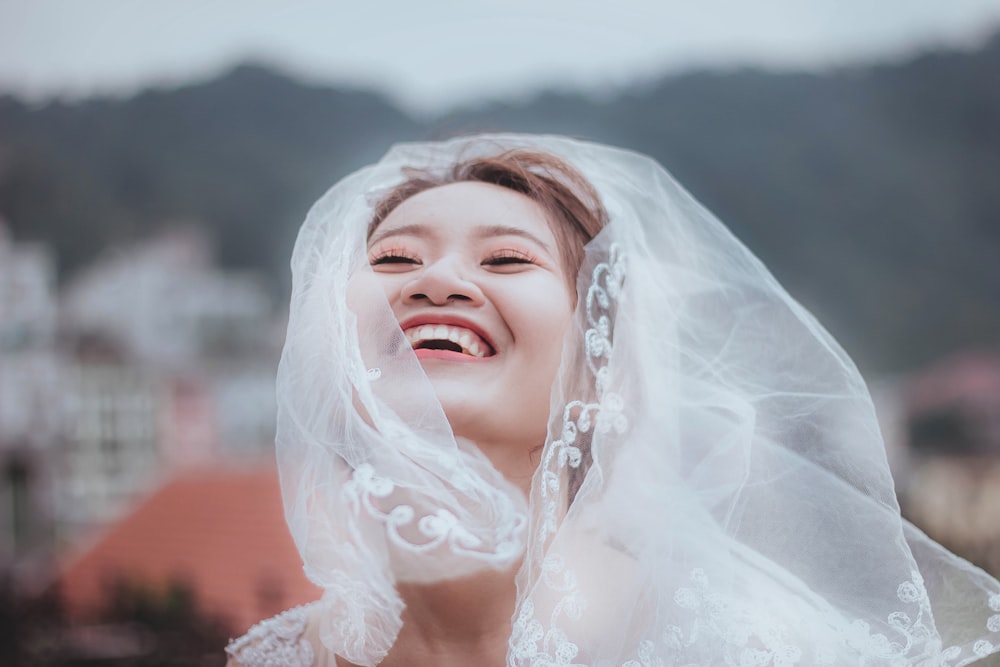 Frau mit weißem Spitzenhochzeitsschleier