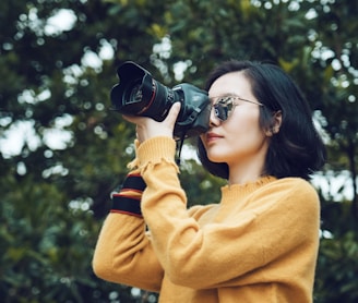 woman taking photo near tree