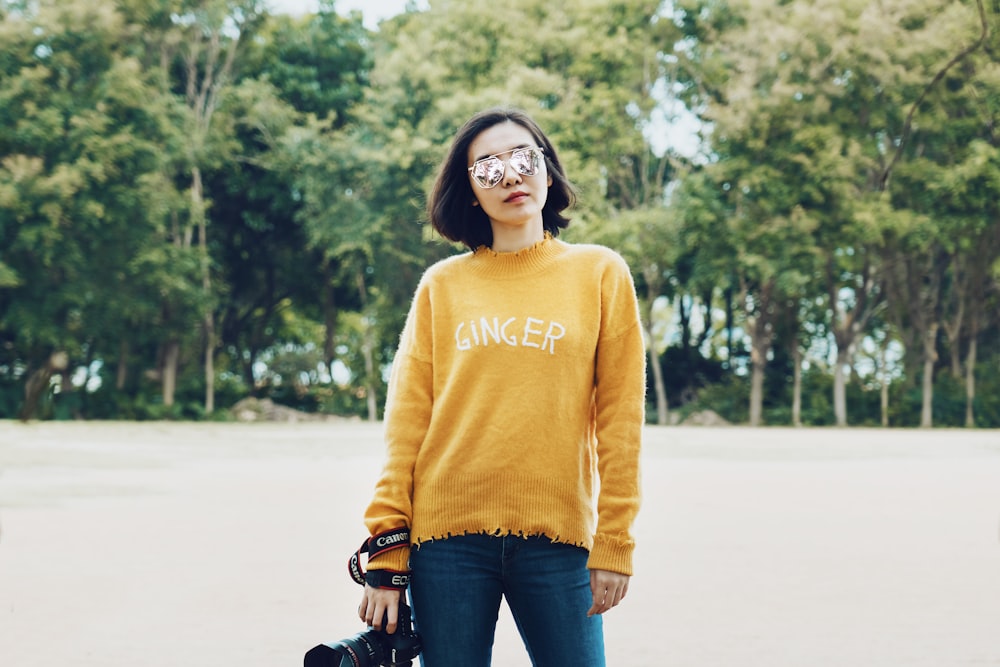 woman carrying black DSLR camera