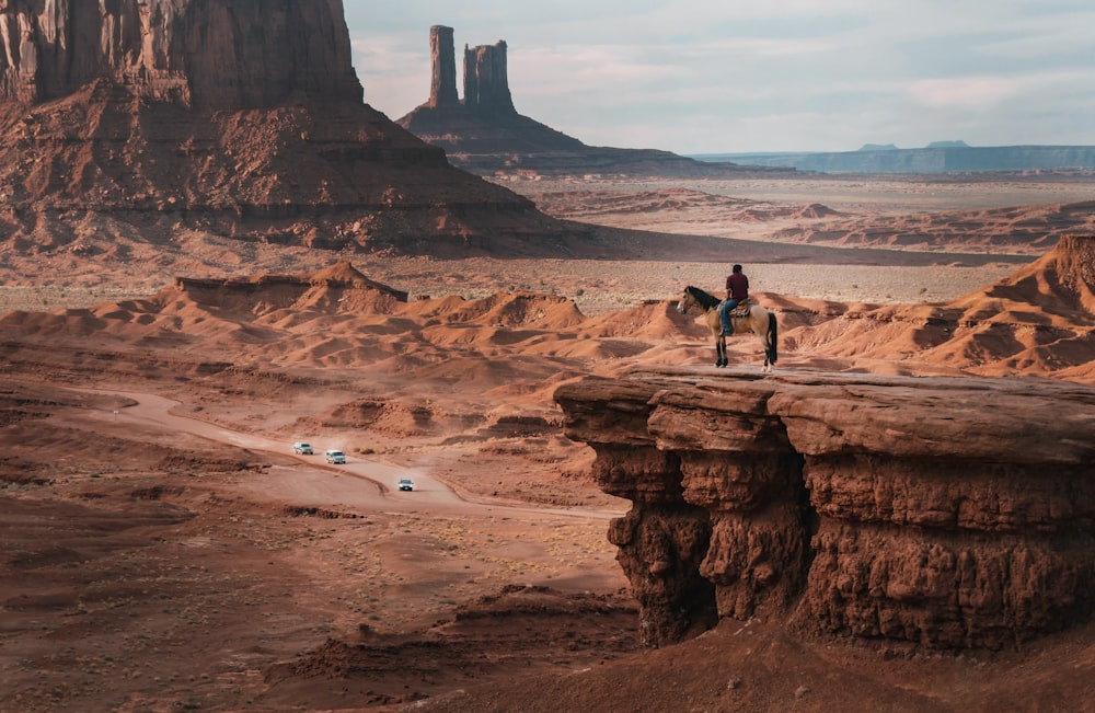 person riding on horse near cliff