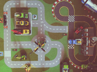 Blocks shaped like various vehicles lined up on a play mat.