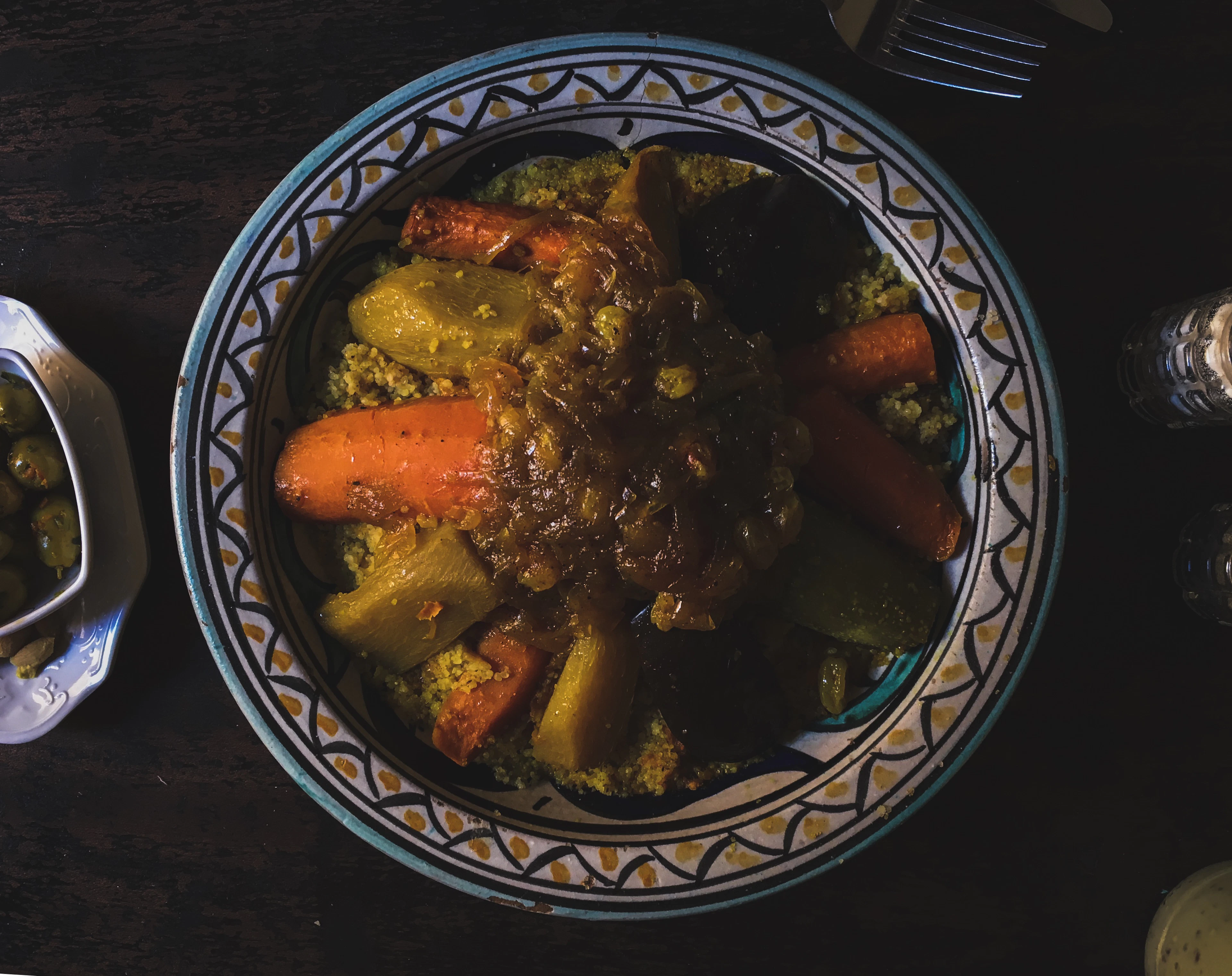 A rich stew served in an ornate bowl under warm light