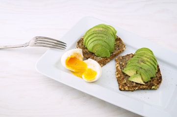rectangular white platter of sliced food and eggs
