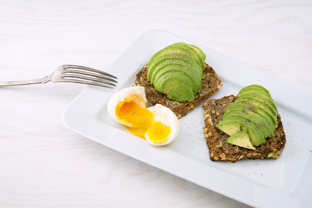 rectangular white platter of sliced food and eggs