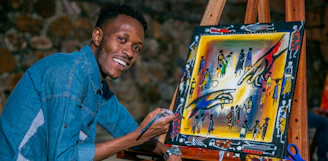 A person smiling while engaging in an online creative arts class.