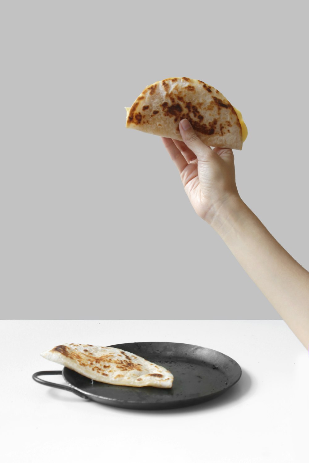 person holding pancake raising it up