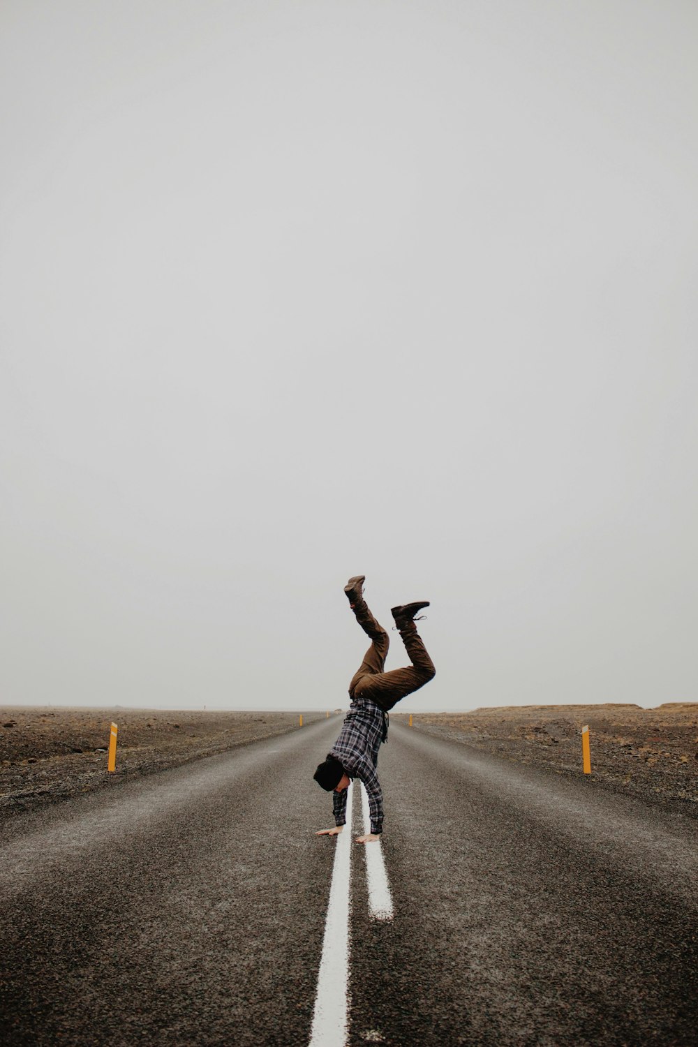 person hand standing on road during daytime