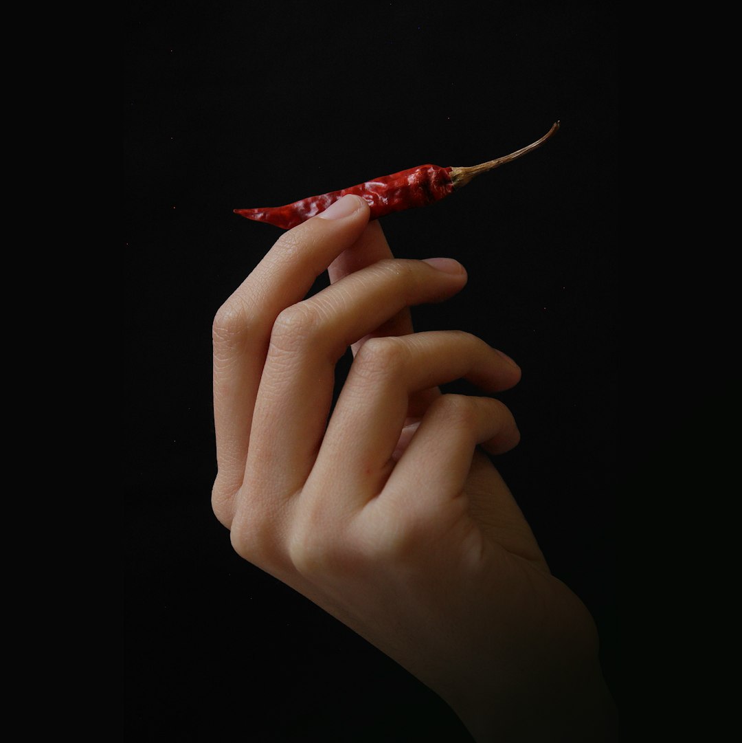 hand holding small red chilli pepper