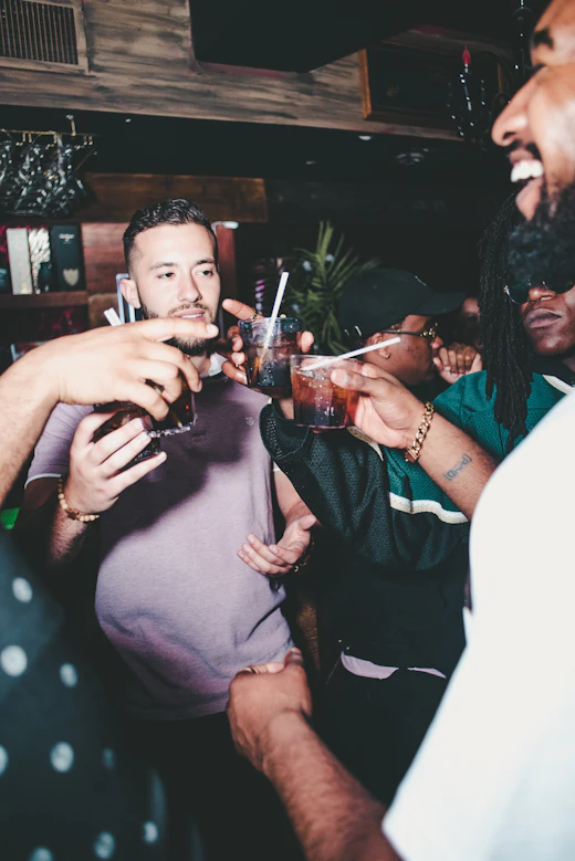 Three friends talking, drinks in hand