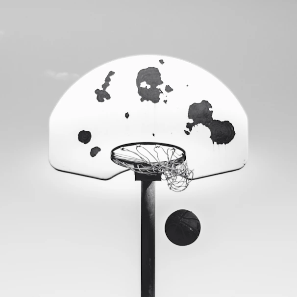 Minimalist shot of a basketball player mid-jump against a stark white background
