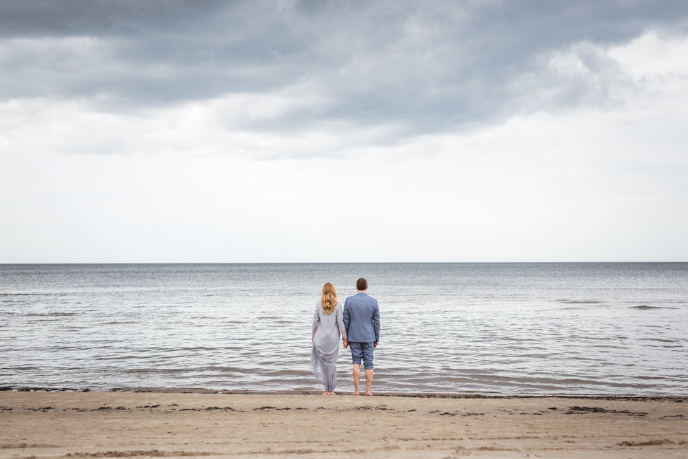 uomo e donna in piedi sulla riva