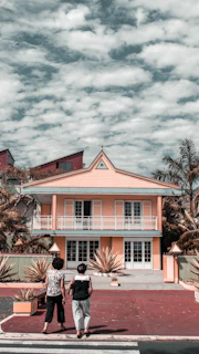 A warm, inviting photo of Payal Patel and Amie Arbid smiling in front of a beautiful Coachella Valley home.
