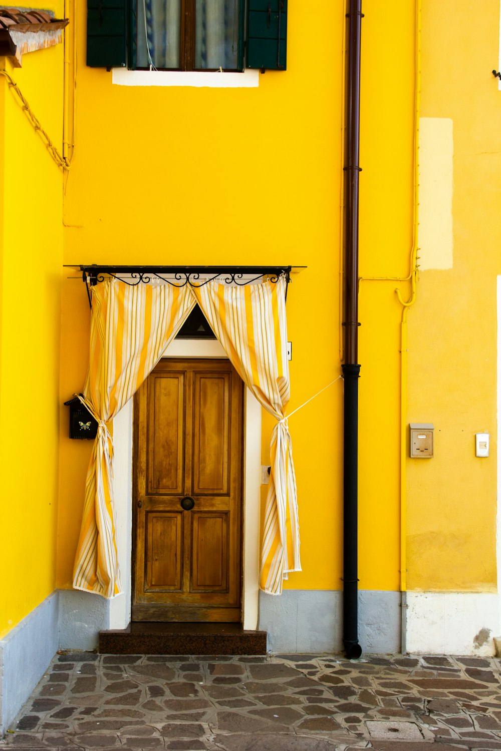 yellow paint house with brown wooden door