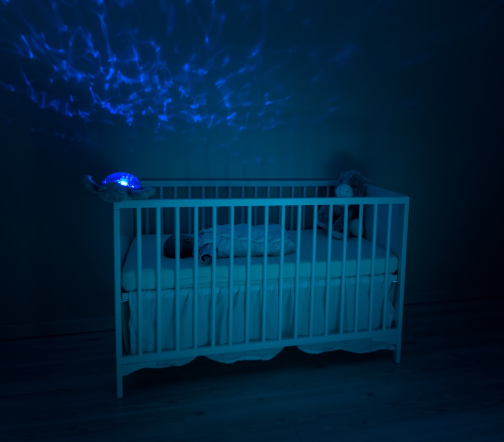 Baby's weiße Holzkrippe Lowlight-Fotografie